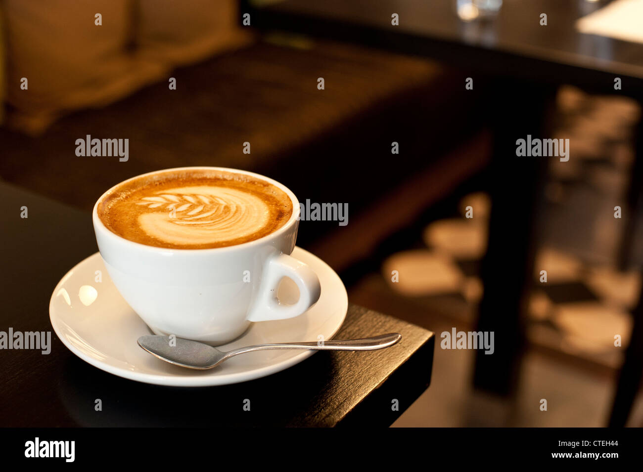 Tazza di cappuccino in un accogliente atmosfera illuminata Foto Stock
