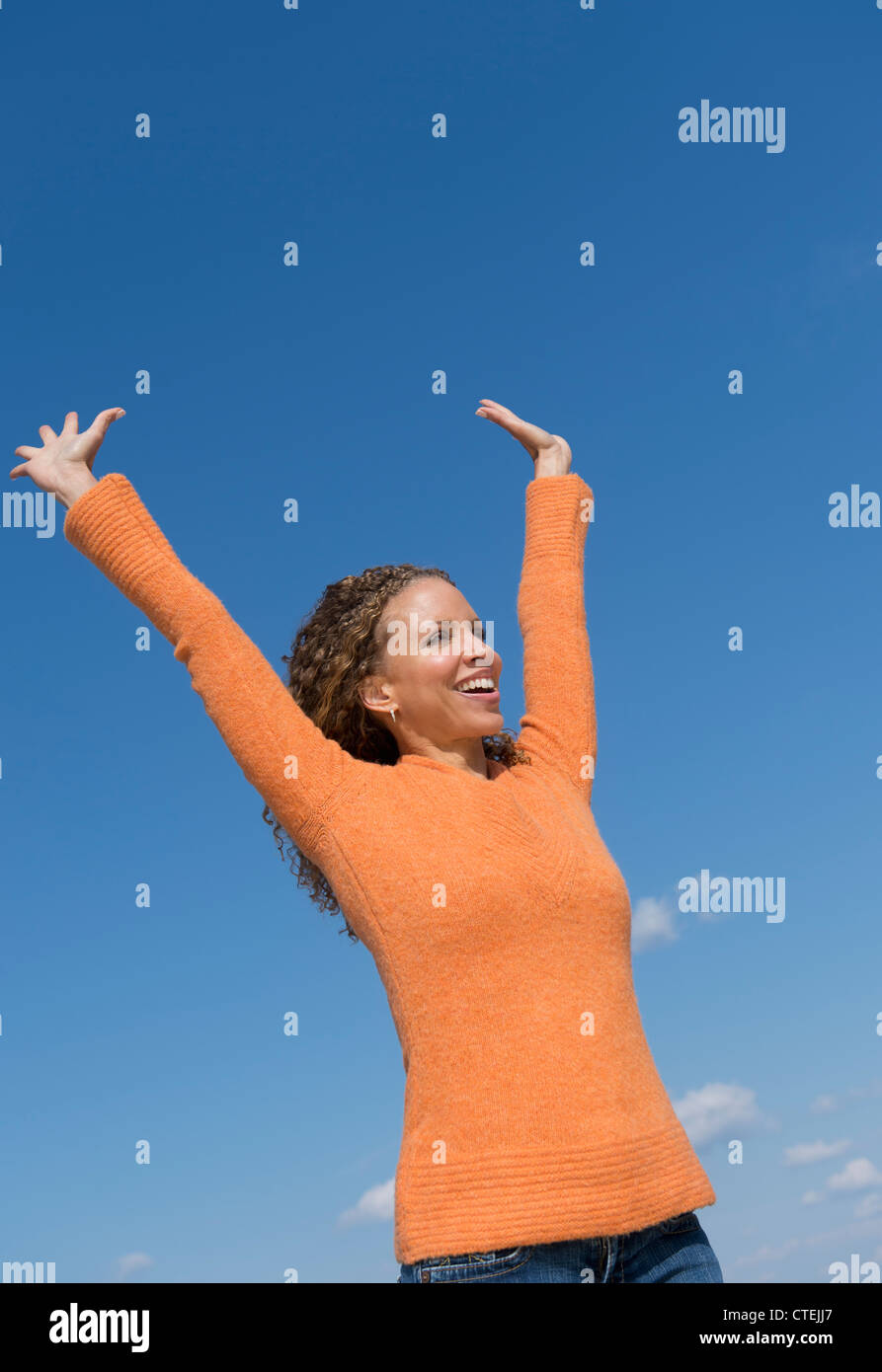 Stati Uniti d'America, New Jersey, Jersey City, donna matura con le braccia alzate verso il cielo blu Foto Stock