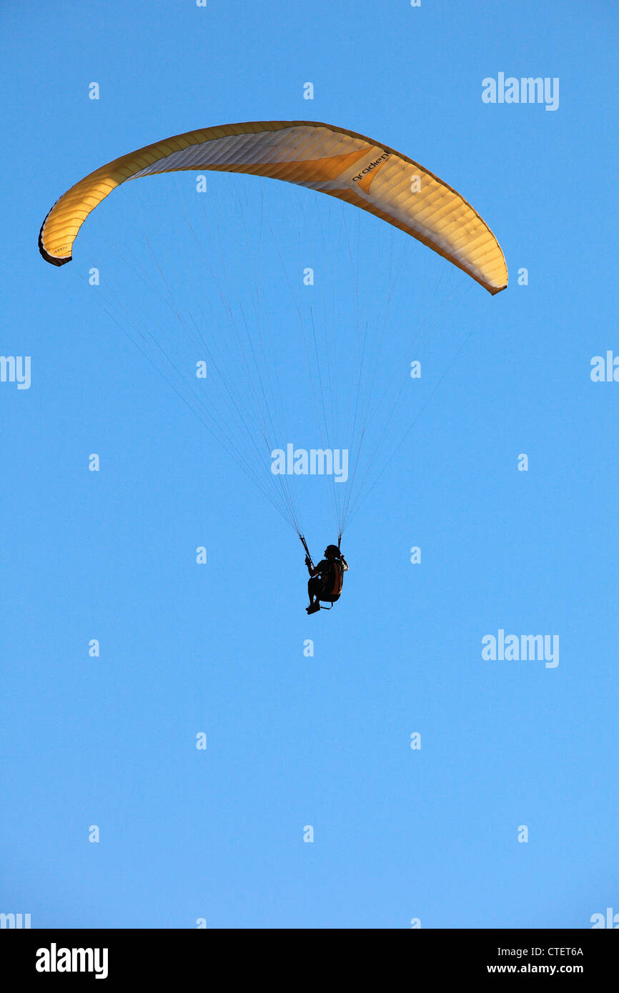 Uomo in su nel cielo in un parapendio Foto Stock