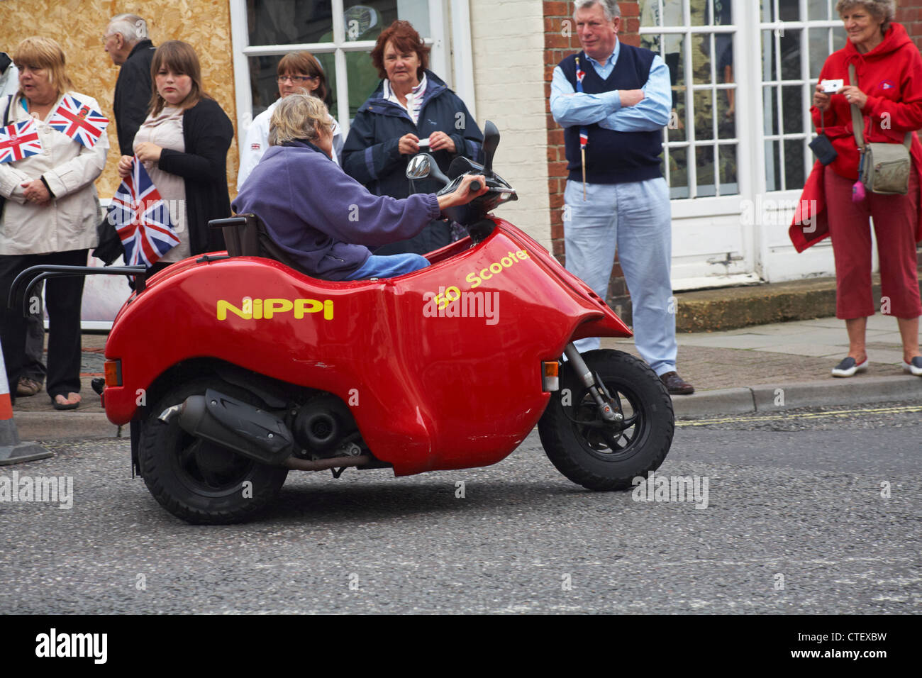 Guida di uno scooter rosso Nippi 50 a Lymington, Hampshire UK nel mese di giugno Foto Stock