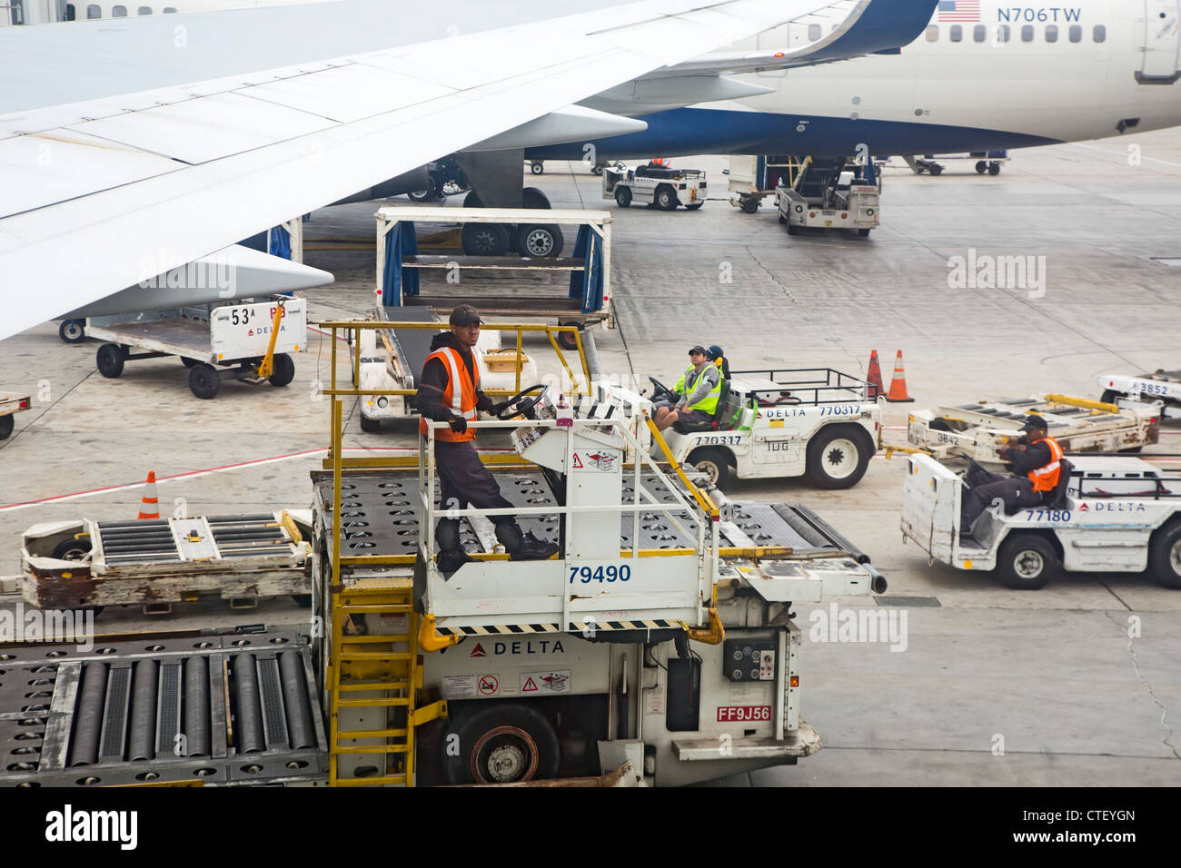 I gestori dei bagagli e la massa di altri membri di equipaggio attendono l arrivo di un Delta Airlines jet presso l'Aeroporto Internazionale di Los Angeles. Foto Stock