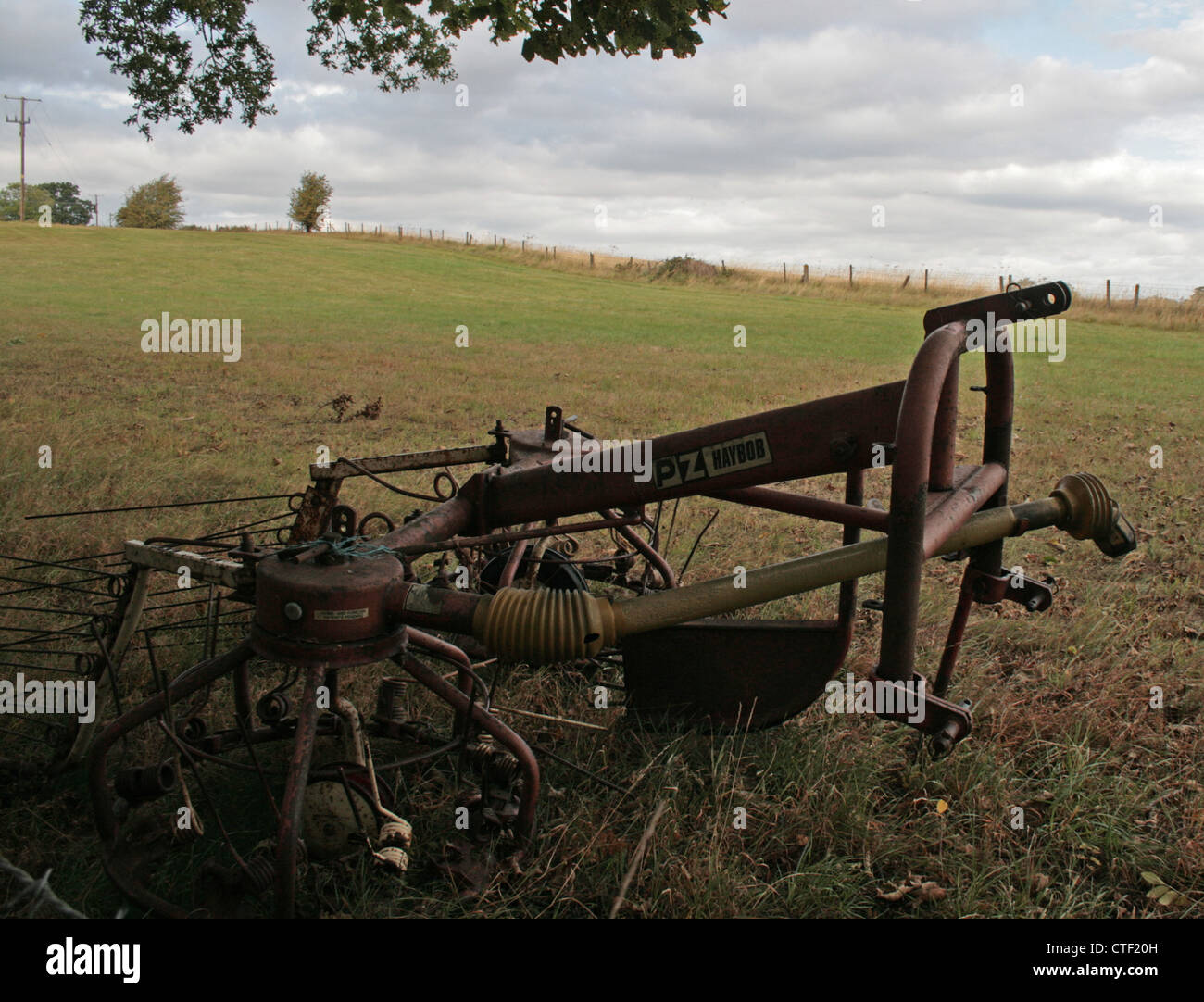 Un meccanizzato rastrello fieno nei campi accanto a Severn House Camping, Shrewsbury, Shropshire Foto Stock