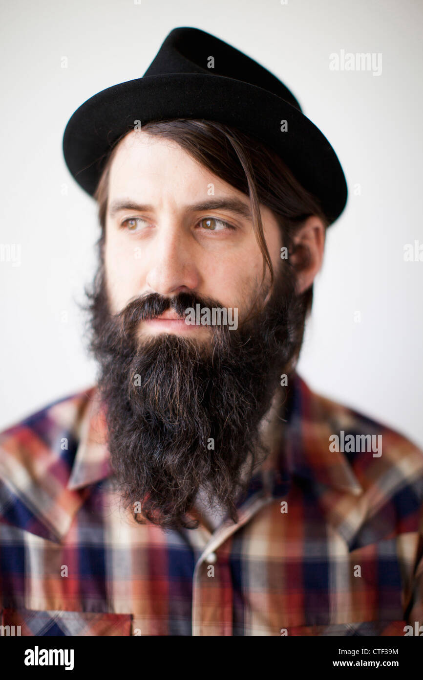 Profilo del personaggio maschile indossando lunga barba, cappello e maglietta lumberjack Foto Stock