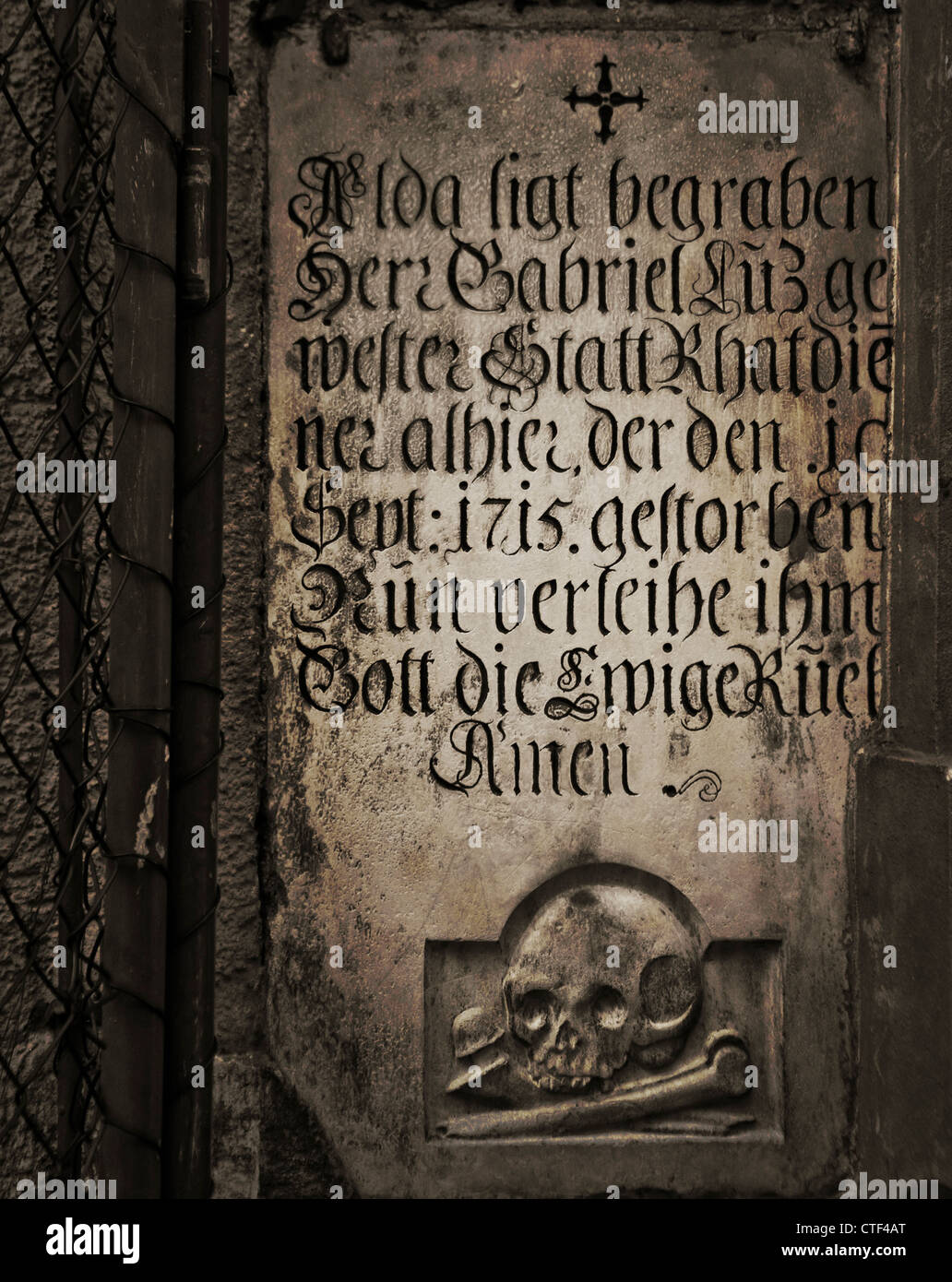 Antica pietra tombale su una chiesa di parete esterna su un grunge texture scuro Foto Stock