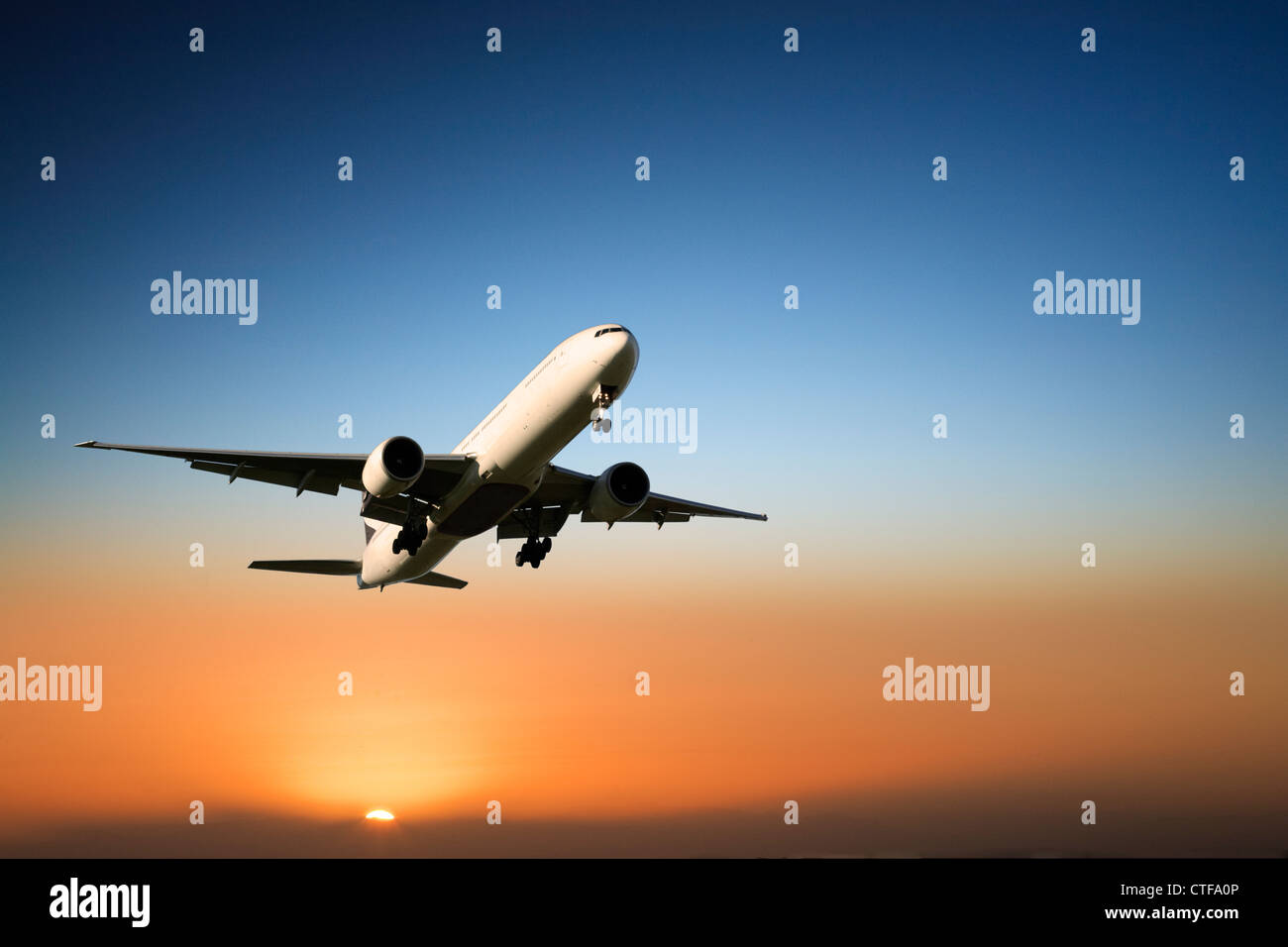 Boeing 777 in arrivo a terra al tramonto. Foto Stock