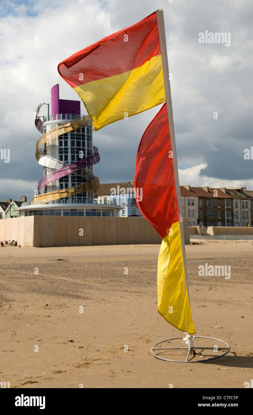 Bagnini bandiera sulla spiaggia a Redcar con molo verticale in background Foto Stock