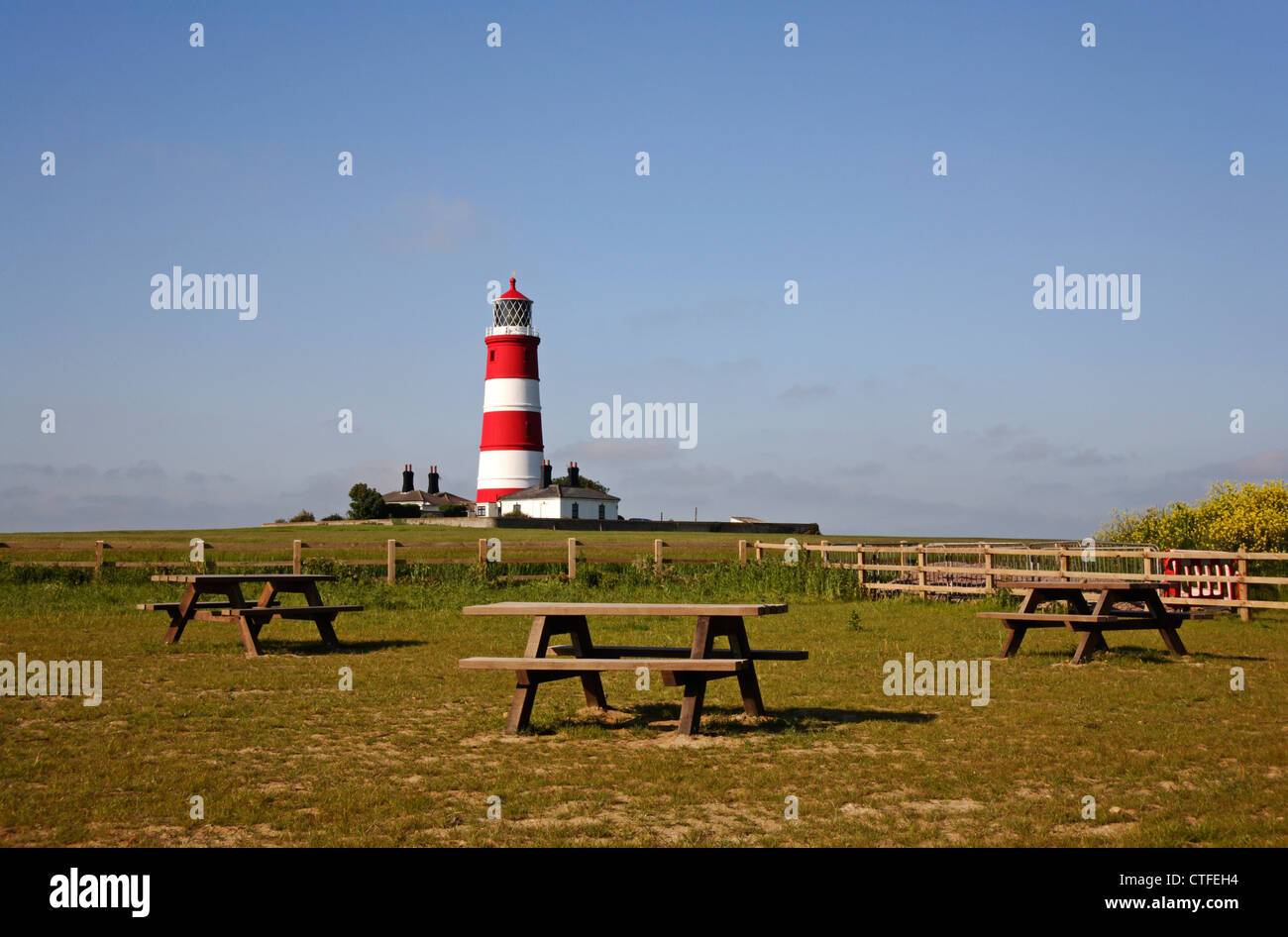 In cima alla scogliera tavoli da pic-nic con il faro in background a Happisburgh, Norfolk, Inghilterra, Regno Unito. Foto Stock