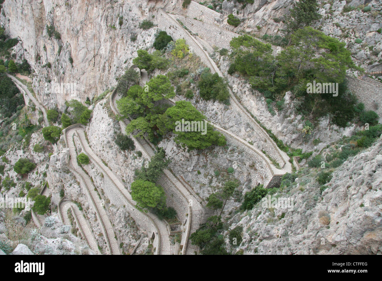 Guardando verso il basso in corrispondenza del perno di capelli di strada che si snoda verso il basso la scogliera di Capri, Italia Foto Stock