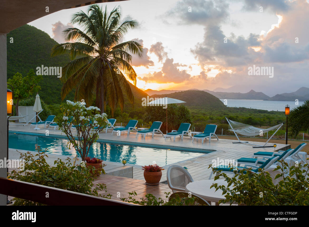 Caribbean West Indies Nevis Mount Nevis Hotel piscina al tramonto con una vista di Saint Kitts - Sera Foto Stock