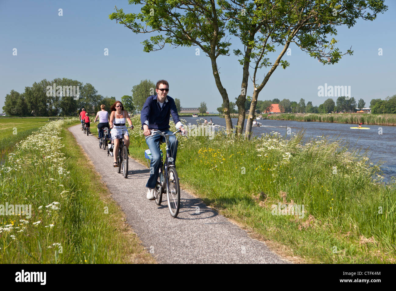 I Paesi Bassi, Wijns, ciclisti escursioni in bicicletta lungo il fiume chiamato Dokkumer Ee. Foto Stock