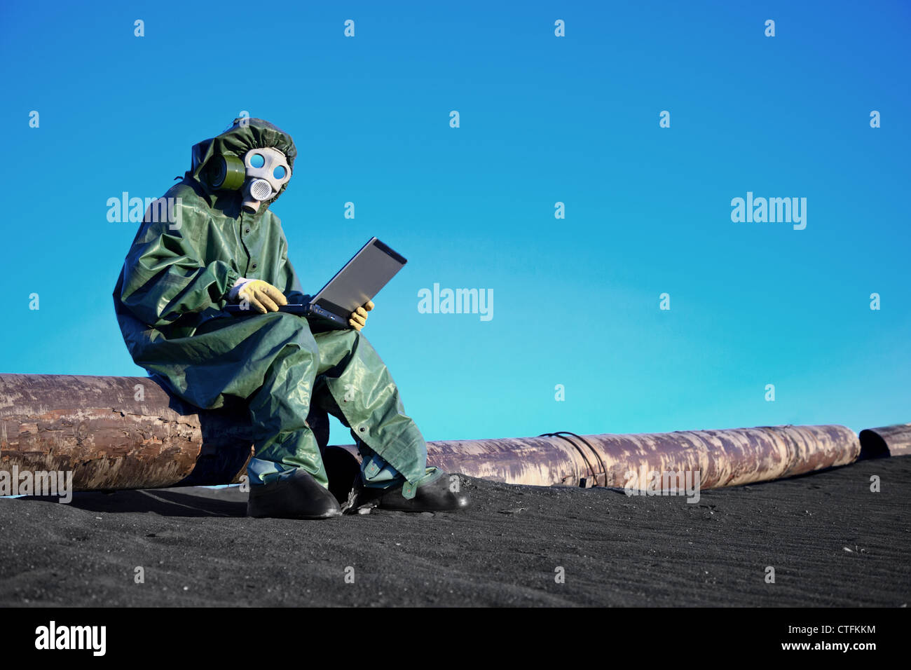 Uno scienziato che lavora con un computer portatile su un chimicamente area contaminata Foto Stock