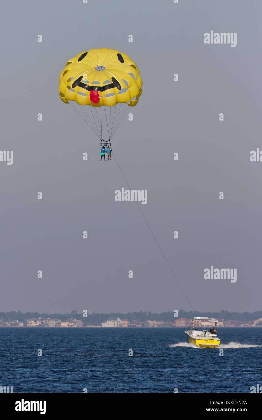 Africa/coppia americana parasailing dietro la barca di traino sulla spiaggia di Pensacola, Florida Foto Stock