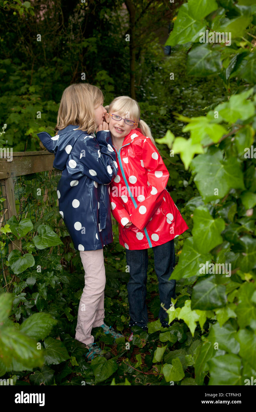 Due giovani amici insieme sia indossando polka impermeabili tratteggiata. Foto Stock