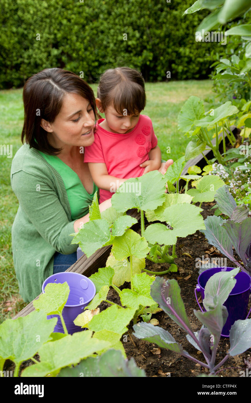 Madre e figlia sono in cerca di piante in un giardino nel cortile. Foto Stock
