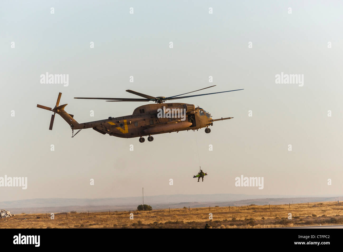 Una forza aerea israeliana CH-53 elicottero durante la ricerca e il salvataggio di formazione, tirando verso l'alto un medic con un 'vittima' su una barella. Foto Stock