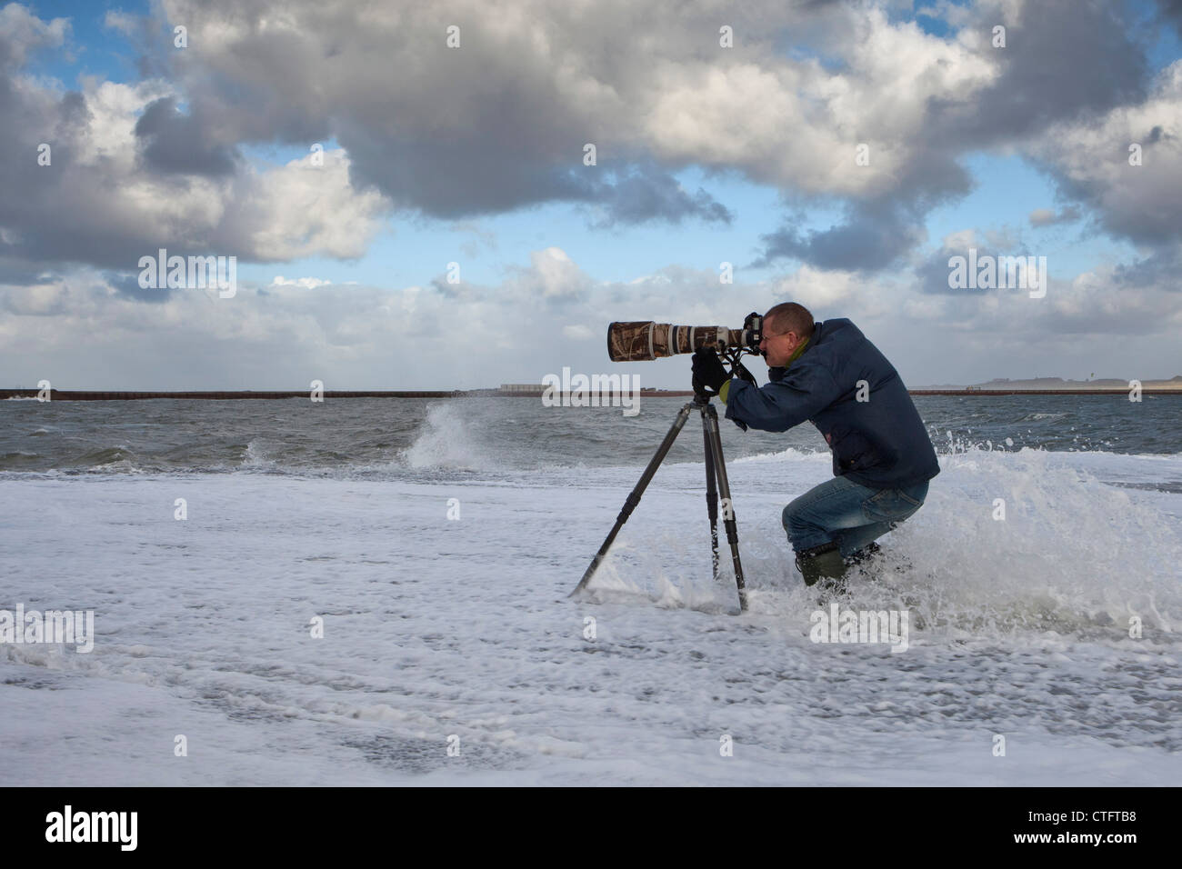 I Paesi Bassi, IJmuiden, fotografo Frans Lemmens sul molo durante la tempesta. Foto Stock