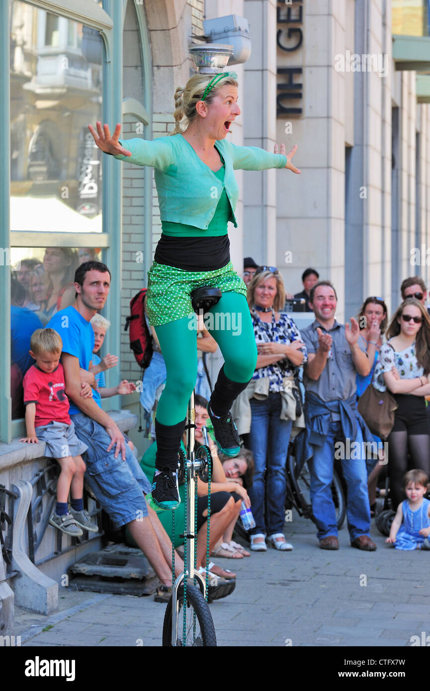 La donna la giocoleria da monociclo come animazione di strada al Gentse Feesten / Gand Festeggiamenti in estate, Belgio Foto Stock