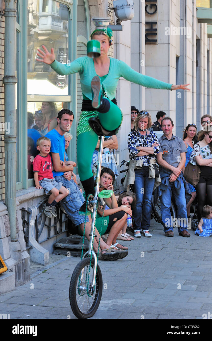 La donna la giocoleria da monociclo come animazione di strada al Gentse Feesten / Gand Festeggiamenti in estate, Belgio Foto Stock