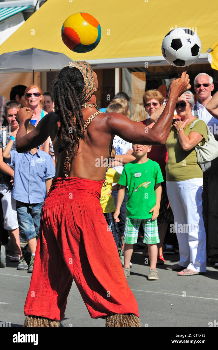 Animazione di strada nero performer giocoleria con palloni da calcio al Gentse Feesten / Gand Festeggiamenti in estate, Belgio Foto Stock
