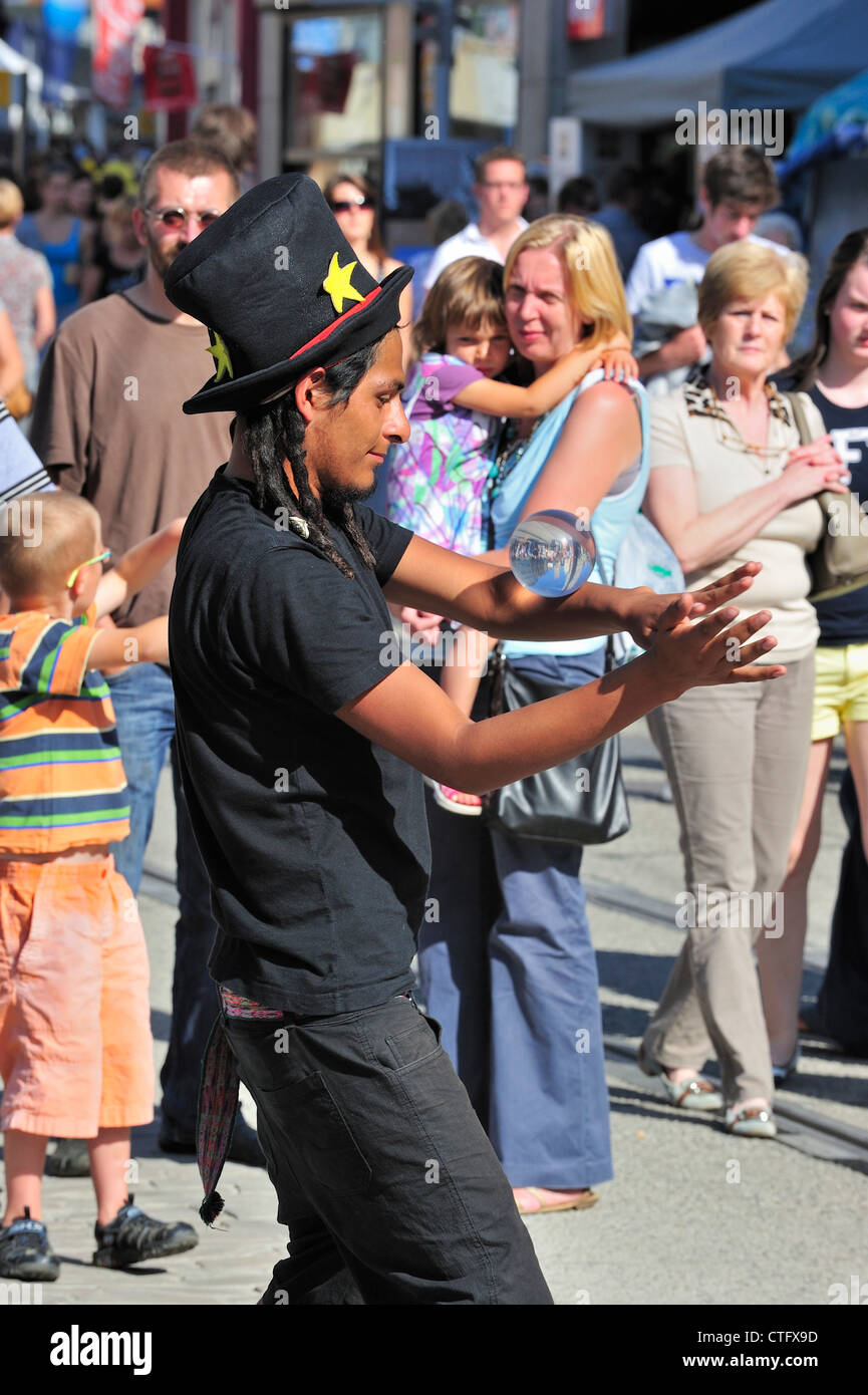 Black street performer equilibratura di Palla di vetro durante l'atto all'Gentse Feesten / Gand Festeggiamenti in estate, Belgio Foto Stock