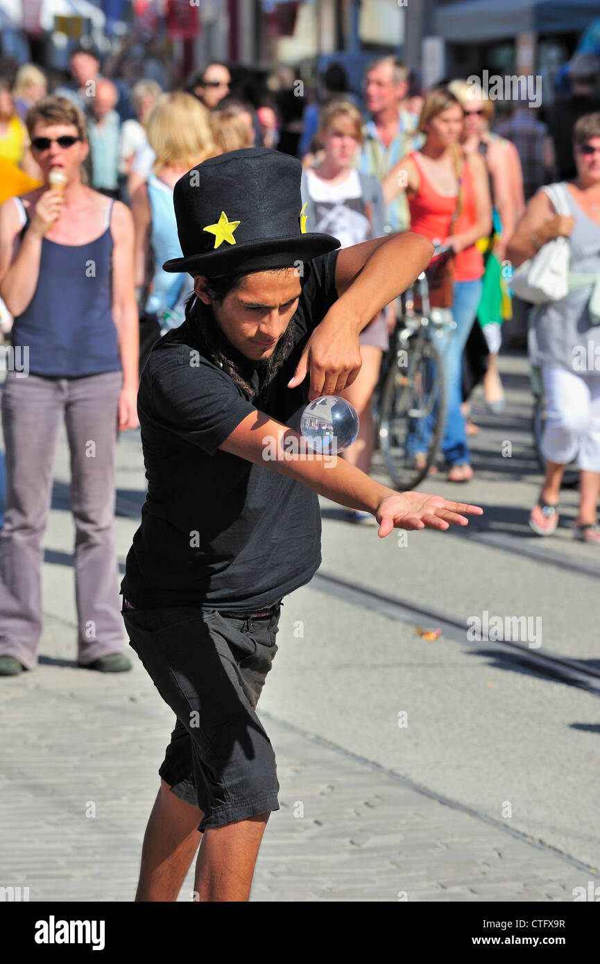 Black street performer equilibratura di Palla di vetro durante l'atto all'Gentse Feesten / Gand Festeggiamenti in estate, Belgio Foto Stock