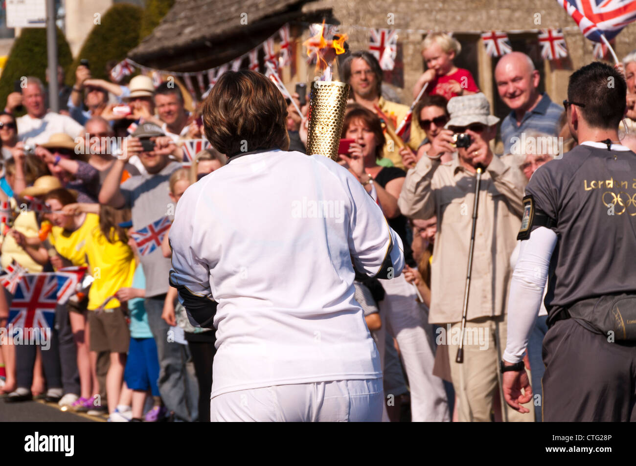 Folla che acclamava Torcia Olimpica bearer, Painswick, Gloucestershire, UK. (23 maggio 2012) Foto Stock