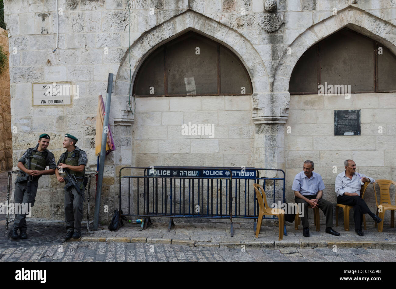 Due israeliani pattuglie di frontiera e due elderli palestinesi in corrispondenza della quinta stazione della Via Dolorosa. Gerusalemme la città vecchia. Israele. Foto Stock