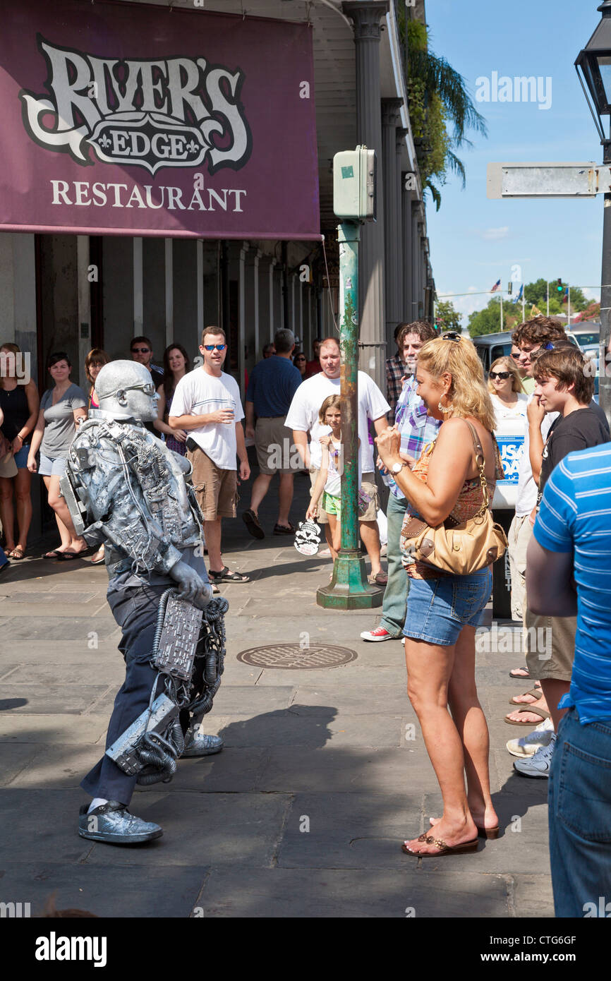 Street performer verniciato argento intrattiene i turisti sul marciapiede nel Quartiere Francese di New Orleans, LA Foto Stock