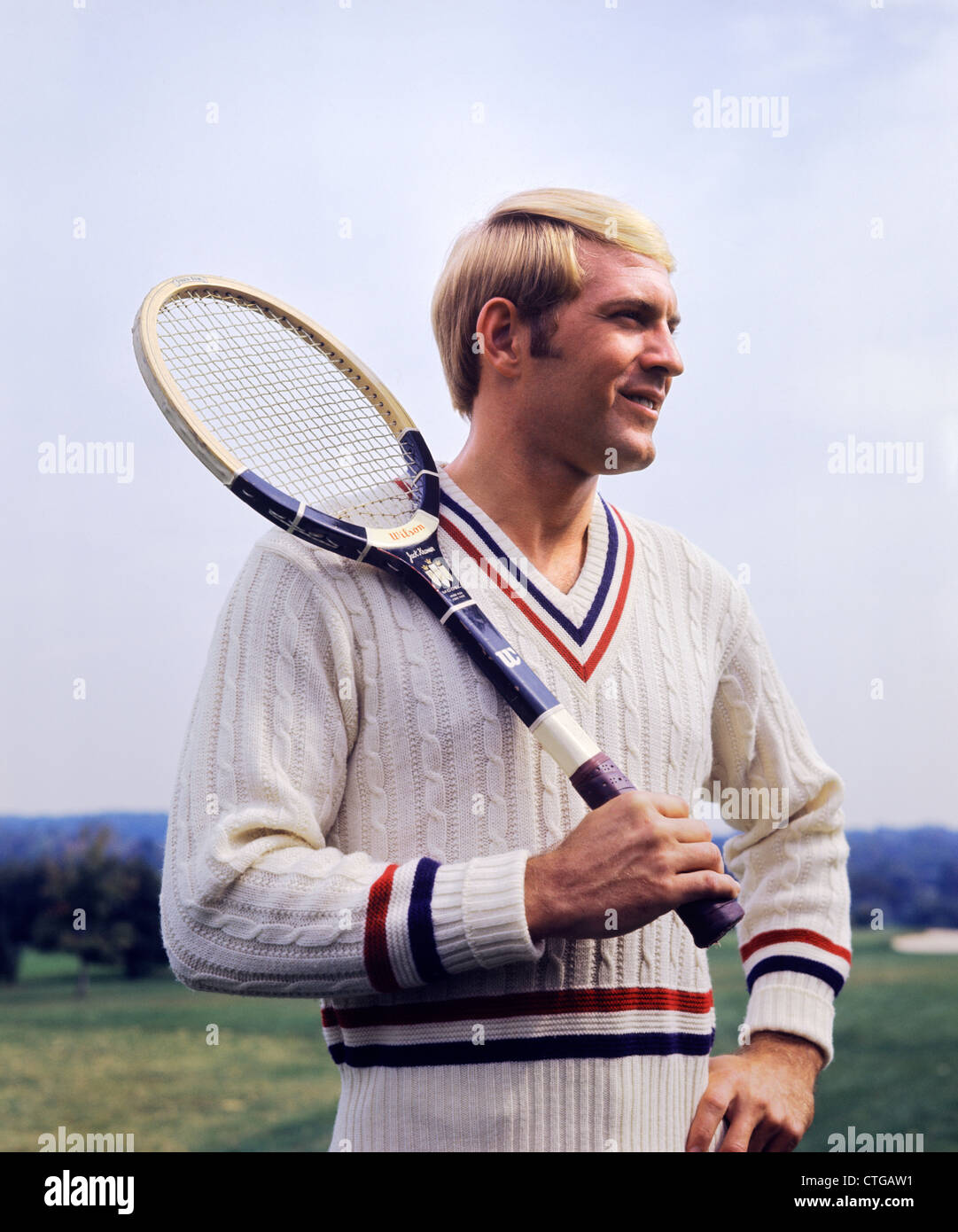 Anni Settanta bionda sorridente uomo che indossa il cavo MAGLIONE MAGLIA  HOLDING racchetta da tennis sulla spalla Foto stock - Alamy