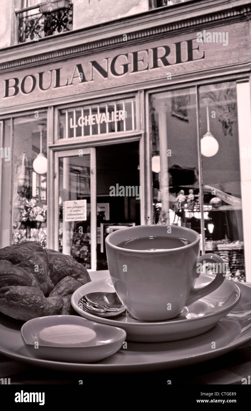 Retrò B&W parigina tipica colazione continentale di caffè e croissant fuori rinomato Boulangerie, Montmartre, Parigi, Francia Foto Stock