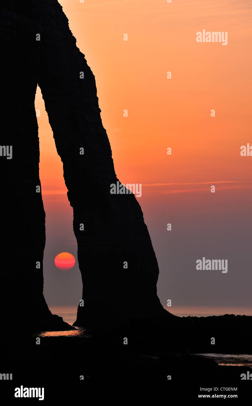 Silhouette di Porte d'Aval, un arco naturale in Chalk Scogliere di Etretat al tramonto, Côte d'Albâtre, Alta Normandia, Francia Foto Stock