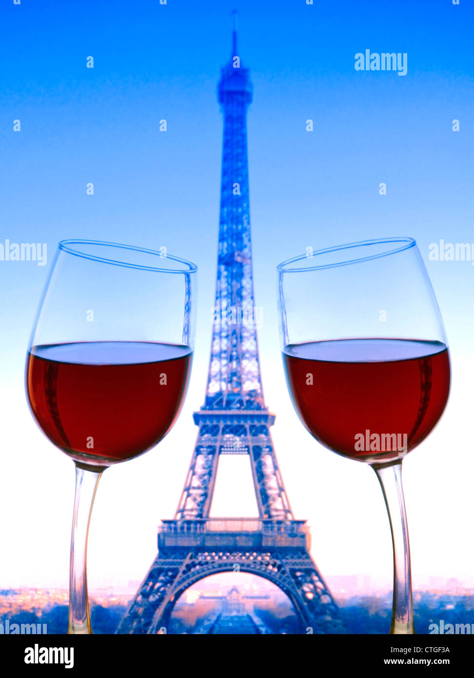 PARIGI SI DIVERTE I bicchieri di vino rosso si appoggiano l'uno verso l'altro con la Torre Eiffel dietro Parigi Francia. Colori bandiera tricolore francese Foto Stock