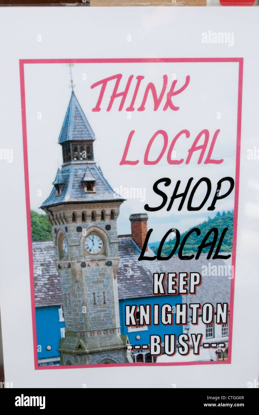 Pensare locale Shop locale Knighton tenere occupato il poster con la città di clock tower Knighton Powys Mid Wales UK Foto Stock