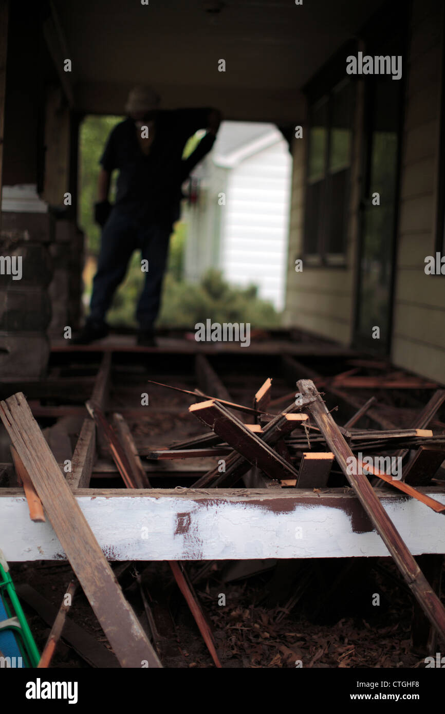 Rottura schede lay sul vecchio incorniciatura di un portico di essere demolito come un lavoratore sondaggi il lavoro. Foto Stock