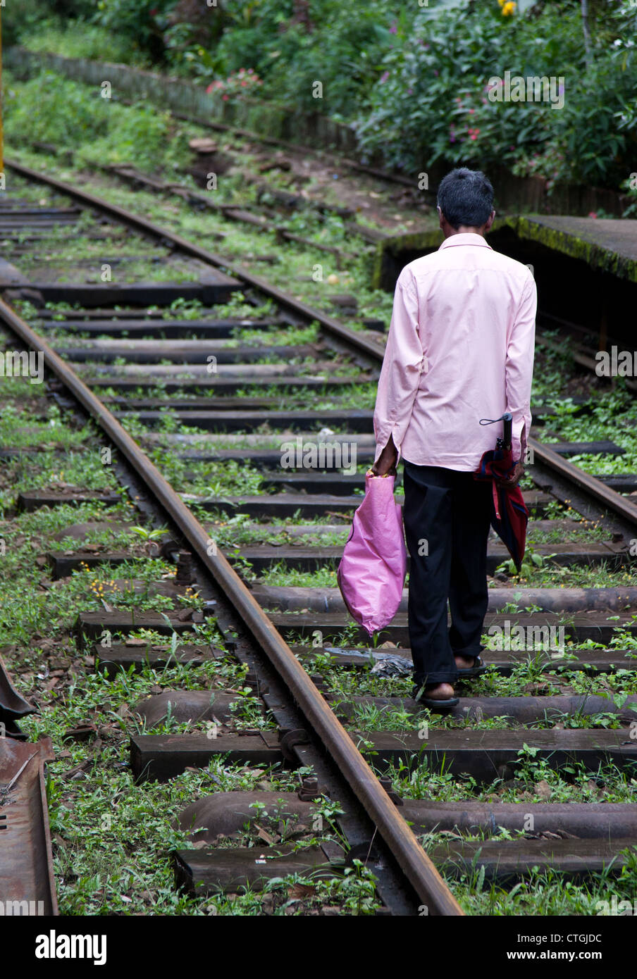 Uomo che cammina su binari ferroviari in Sri Lanka, nella collina centrale Regione Foto Stock