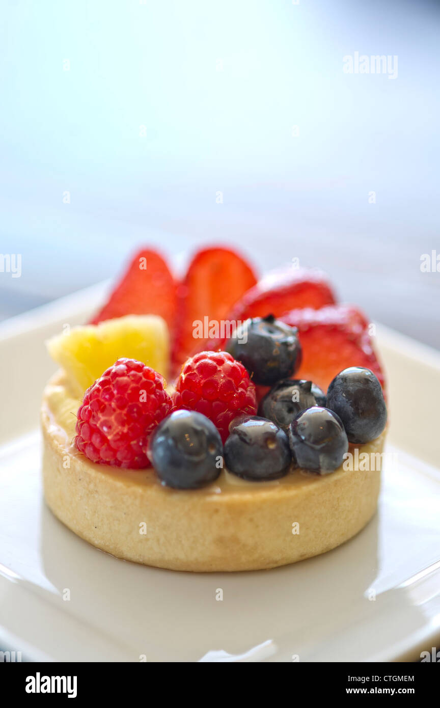 Un misto di frutti di bosco tart su una piastra in corrispondenza di un panificio. Foto Stock