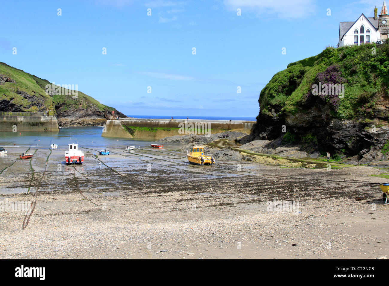 Immagine del paesaggio di Port Isaac Harbour in Cornovaglia con la bassa marea che mostra le barche dei pescatori e degli edifici che si affaccia sul porto. Foto Stock