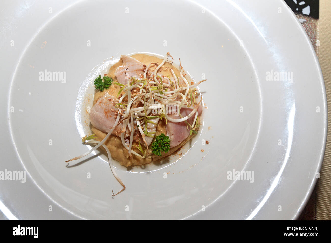 Tonno rosso sul pulcino purea di piselli con i germogli. Un aperitivo servito presso un ristorante elegante. Foto Stock