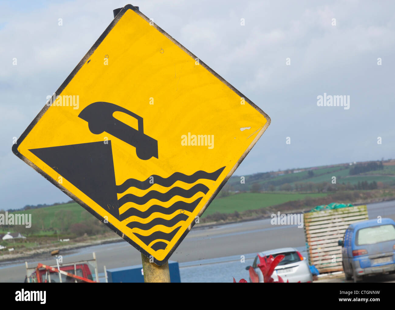 Courtmacsherry-Timoleague estuario, West Cork, Irlanda. Segnaletica di avvertimento pericolo di andare troppo vicino al bordo del molo. Foto Stock