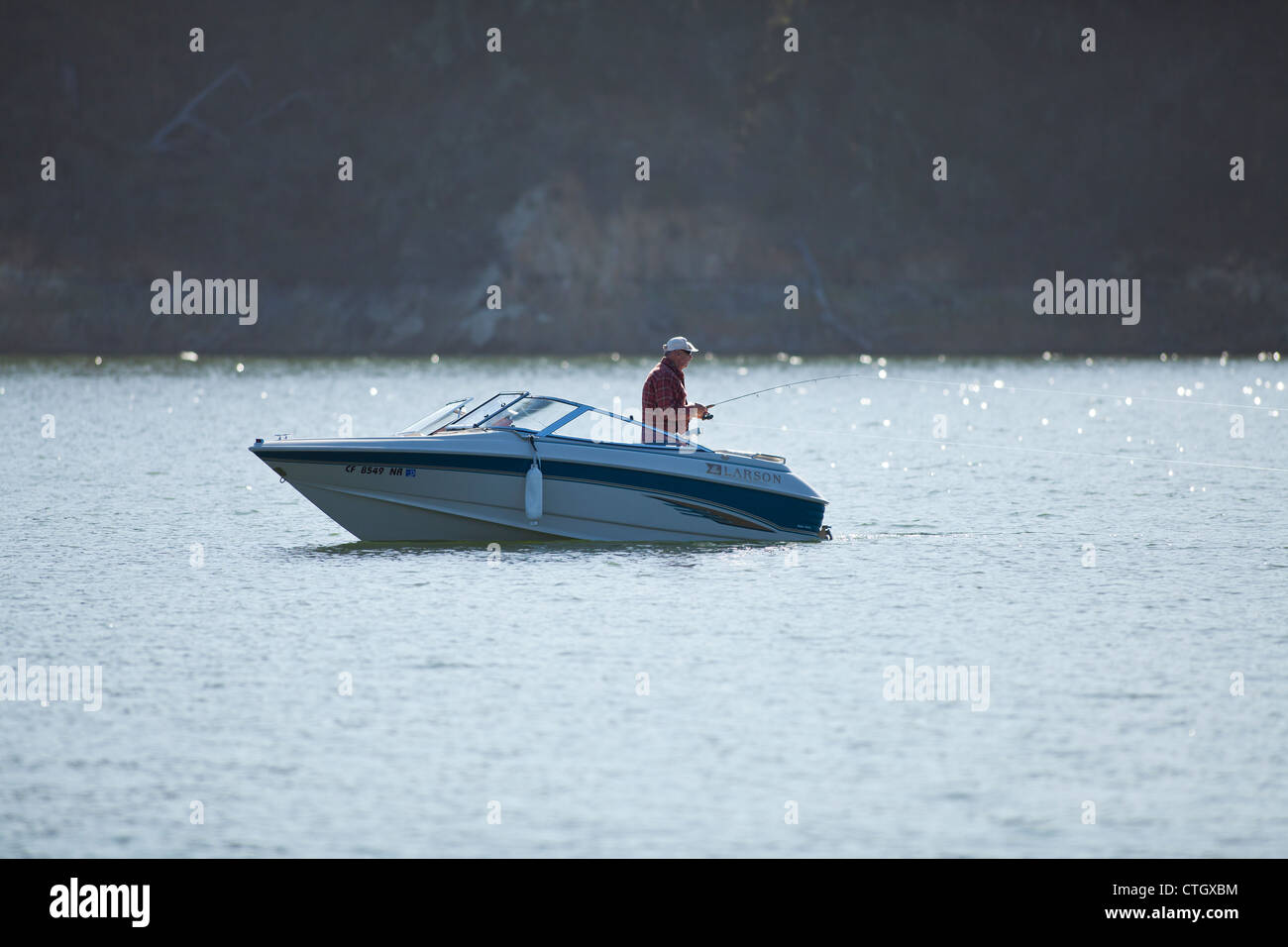 Pescatore in una barca traina per la trota lago Cachuma, Santa Ynez Valley, California, Stati Uniti d'America Foto Stock
