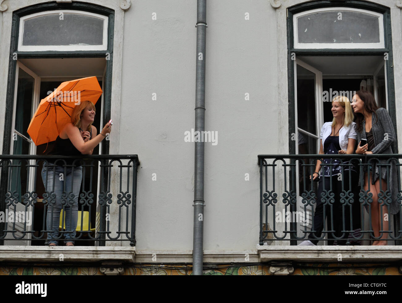 Le donne di scattare una foto su un balcone della casa. Foto Stock