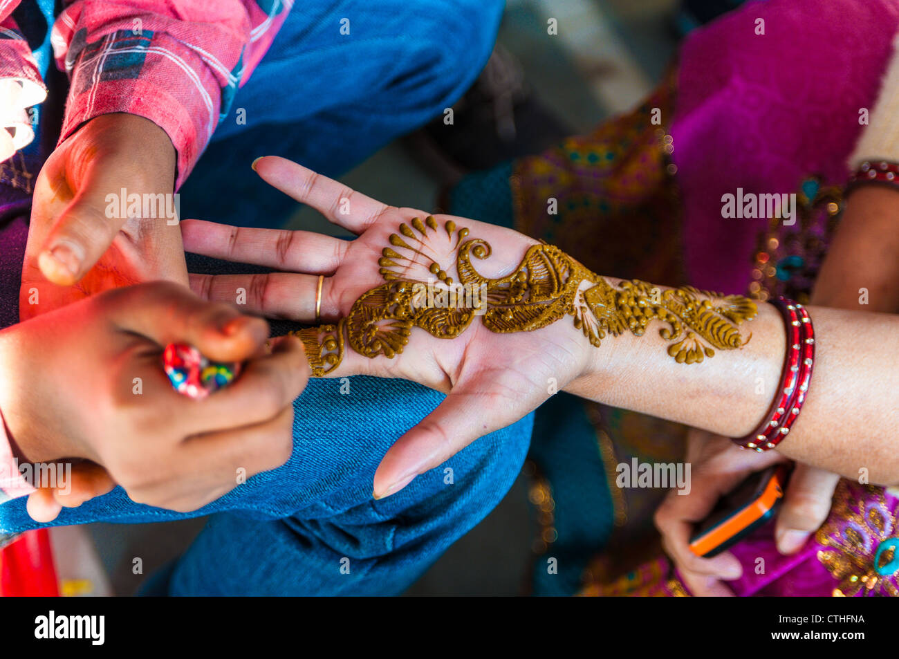 Una donna indiana ottiene Henna Tattoos sulle mani, India Foto Stock