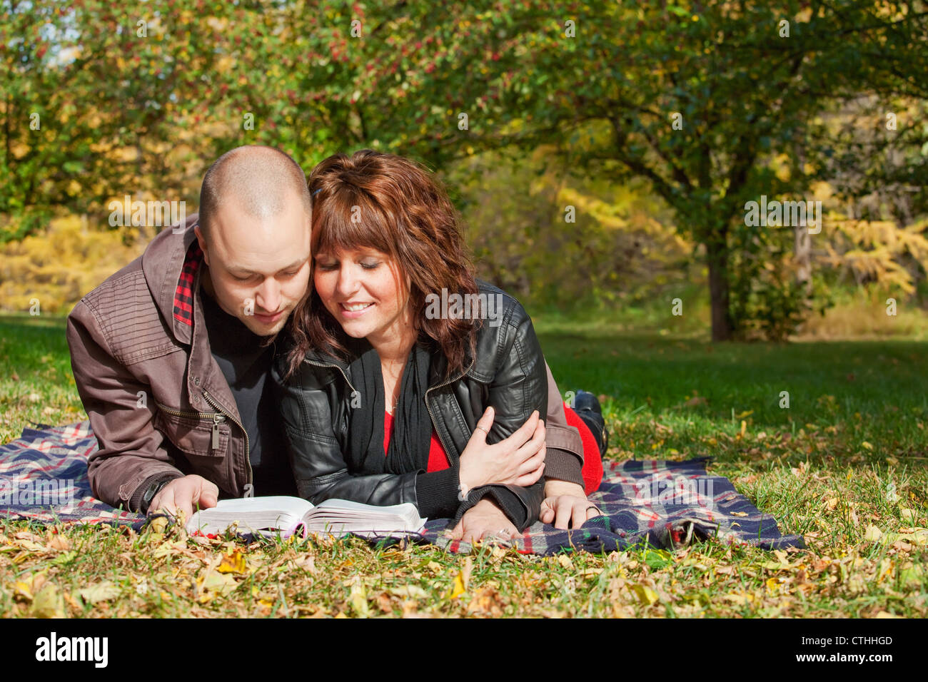 Giovane leggendo la Bibbia insieme in un parco; Edmonton, Alberta, Canada Foto Stock