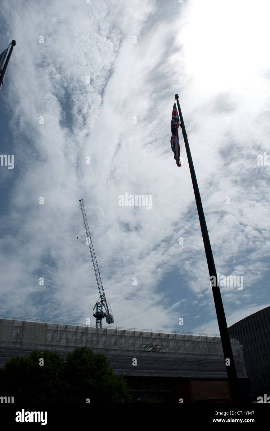 Bandiera europea e pennone parallelamente alla gru a torre in background stagliano cielo drammatico Foto Stock