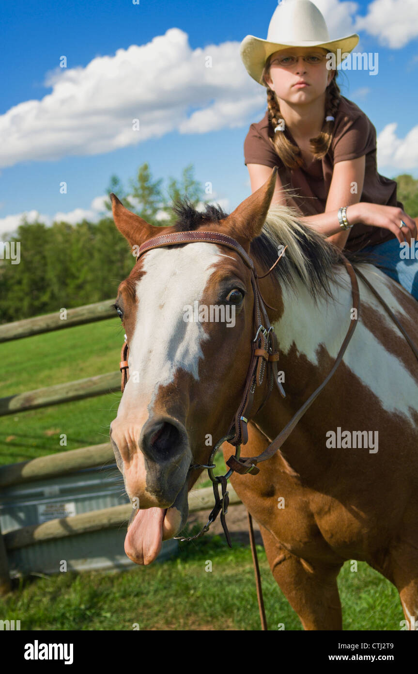 Horse effettuando una divertente faccia mentre è guidato da un giovane Cowgirl; Edmonton, Alberta, Canada Foto Stock