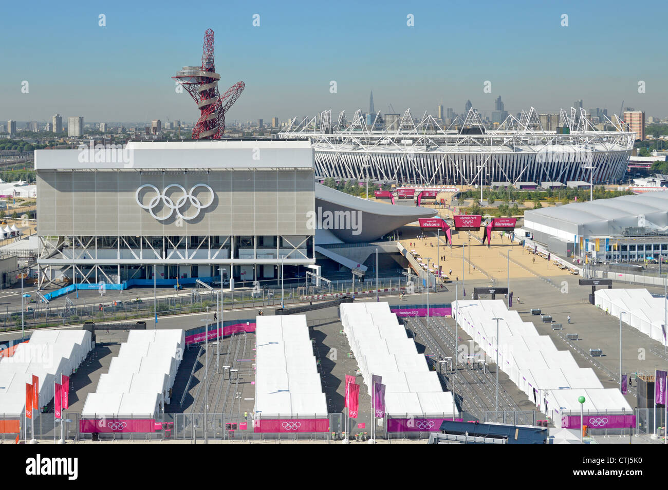 Completato Centro Acquatico del Parco Olimpico e la Torre dell'orbita di ArcelorMittal Principali stadi sportivi e file bianche tende di sicurezza per spettatori Londra Skyline Regno Unito Foto Stock