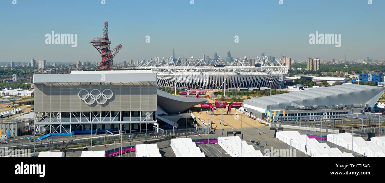 Guardando verso il basso sulla Olympic Park Aquatic Centre & orbita torre sinistra, stadio principale medio, polo d'acqua diritto & City of London skyline distante Stratford REGNO UNITO Foto Stock