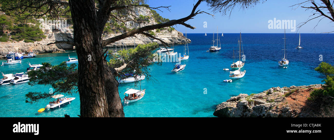 Barche a vela nella piccola baia di Cala Trebaluger resort, isola di Minorca, Isole Baleari, Spagna, Europa Foto Stock