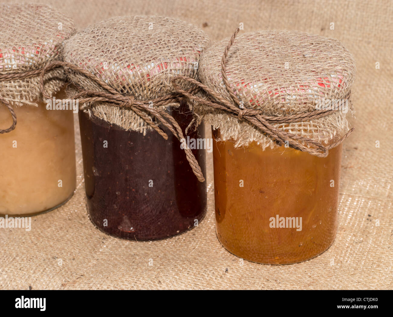 Fresche marmellata fatta in vasi su sfondo rustico Foto Stock