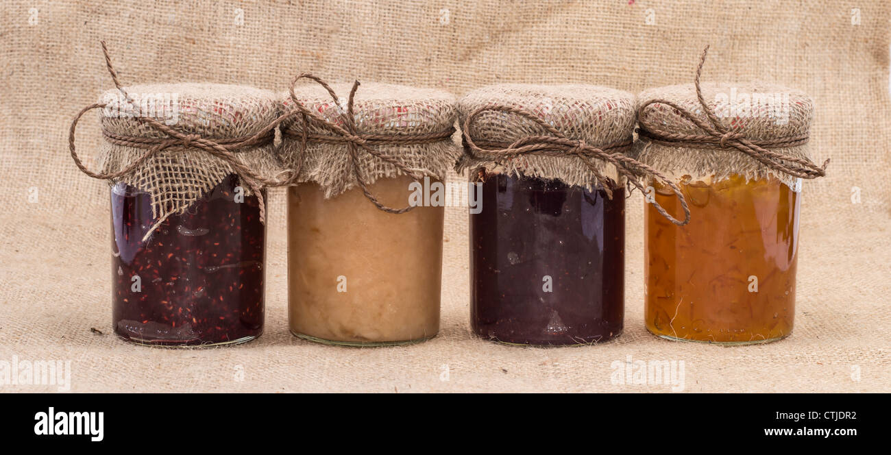Fresche marmellata fatta in vasi su sfondo rustico Foto Stock